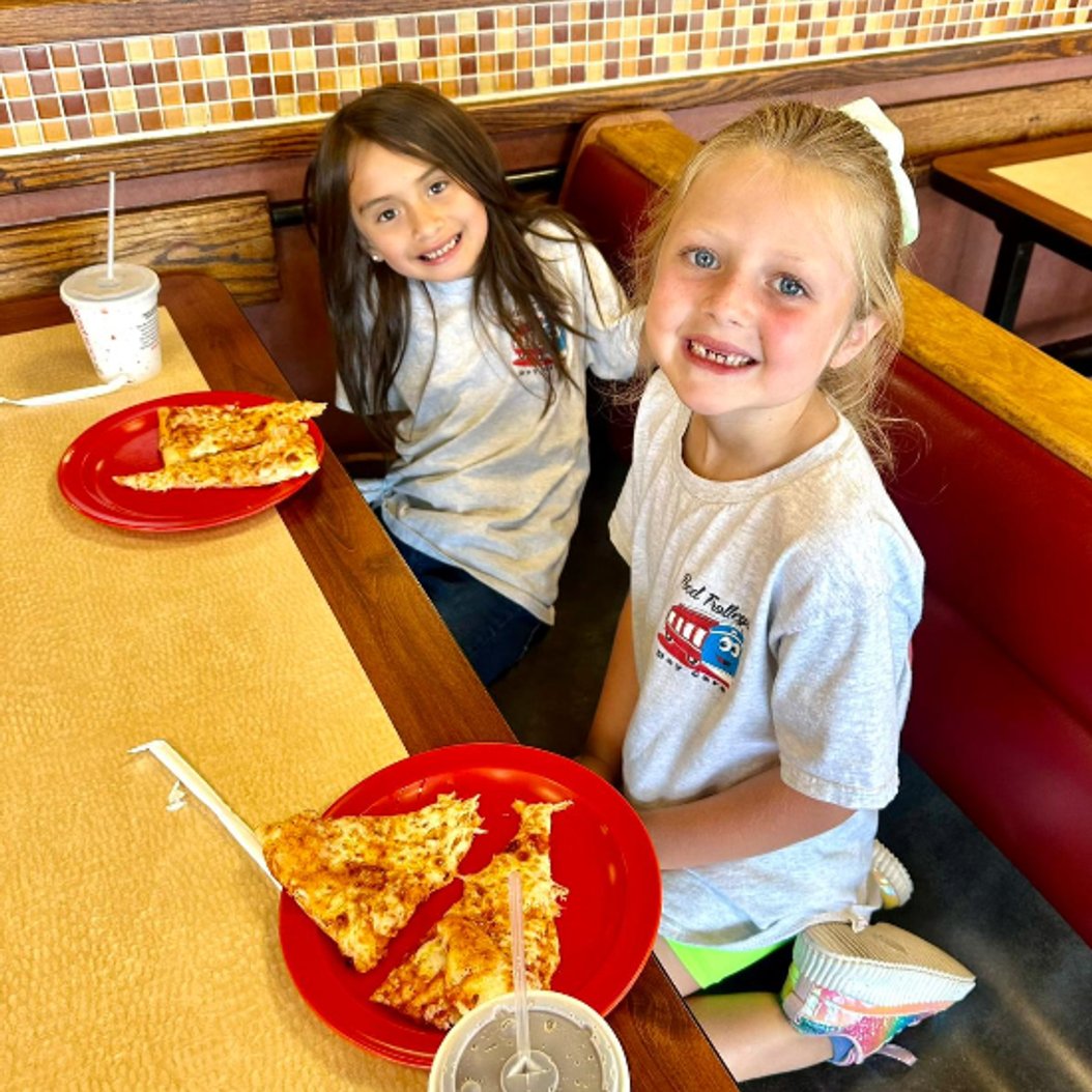 Children enjoying pizza at Red Trolleys Daycare in Valdosta, GA. Nurturing environment for child care and preschool.